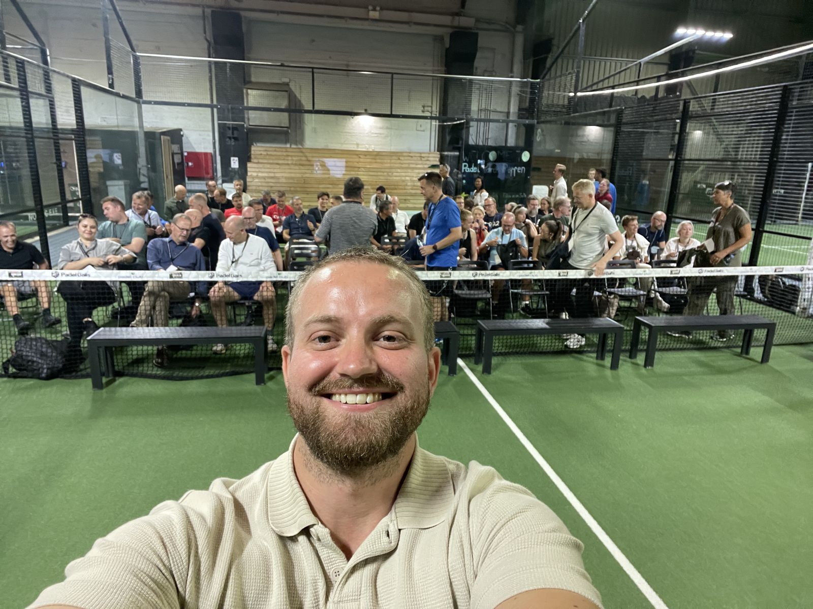 Rasmus foran publikum, der er klar til foredrag i en padelhal